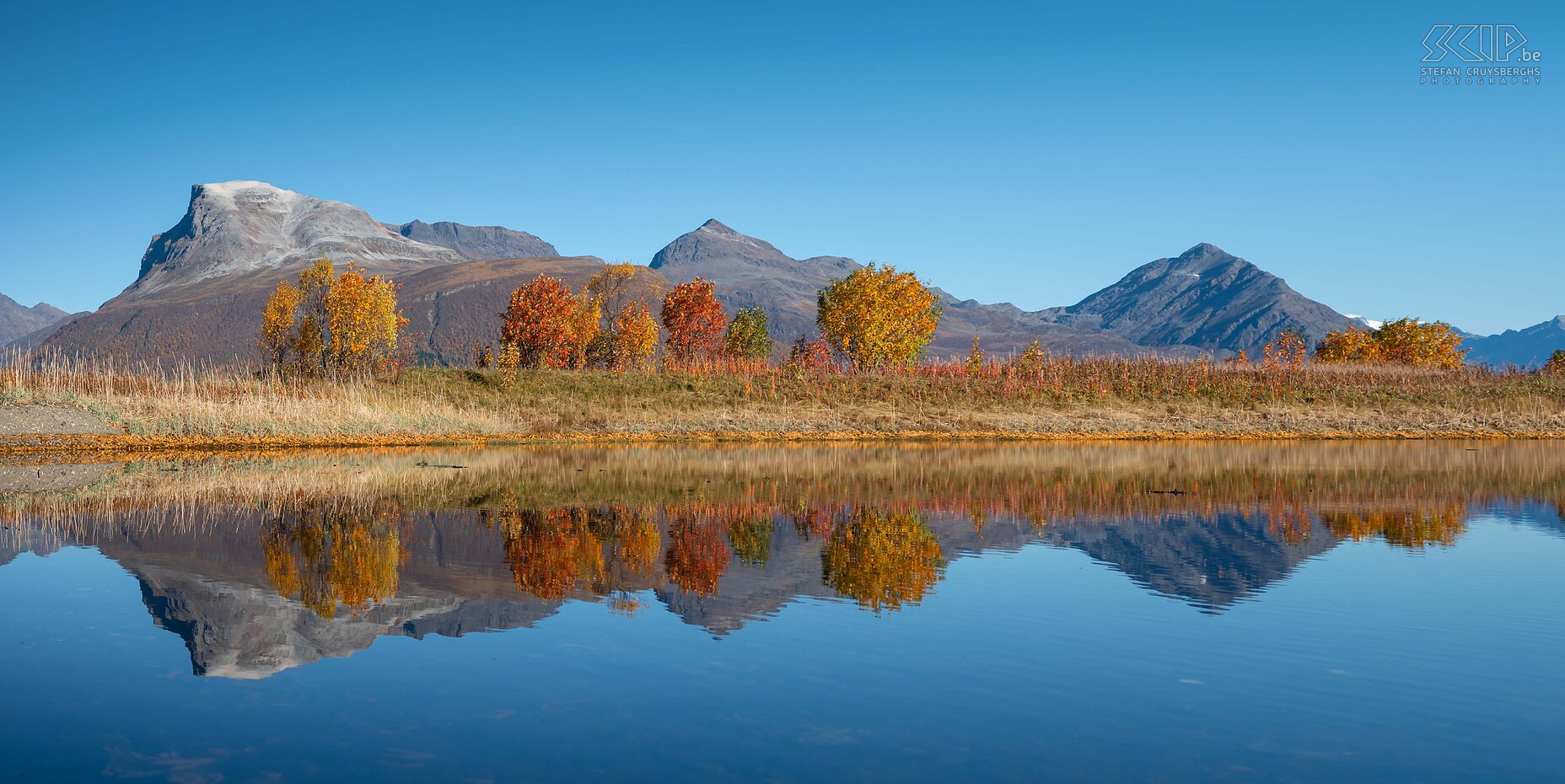 Storsteinnes A clear blue sky, trees with beautiful autumn colors and their reflection in a pond on the Balfsfjorden in the village of Storsteinnes Stefan Cruysberghs